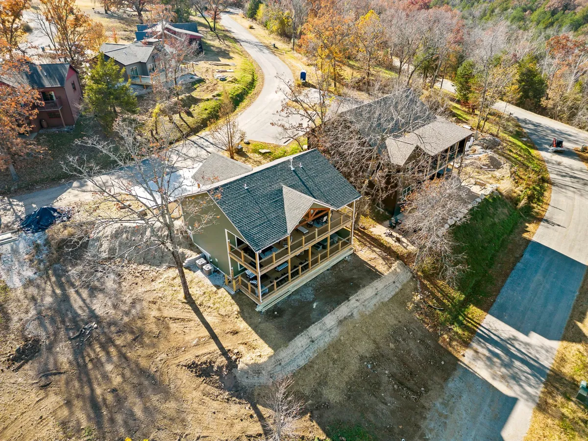 This image presents two newly constructed houses nestled amidst trees and nature, with a curving road leading through the tranquil landscape. The setting is peaceful, inviting, and hints at the privacy and exclusivity of the getaway.
