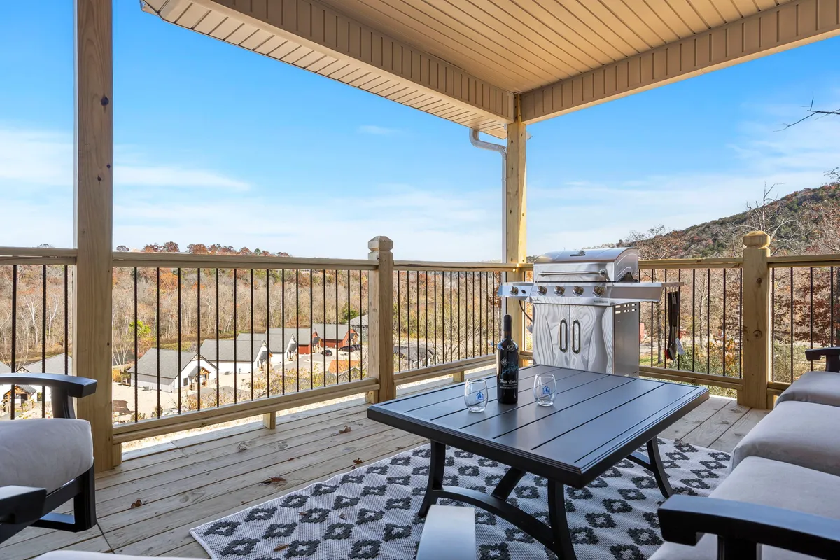 A comfortable outdoor seating area with a grill and table overlooks a distant landscape, inviting guests to unwind after a day of adventure. The setup is ideal for evening barbecues, stargazing, or morning coffee surrounded by nature.