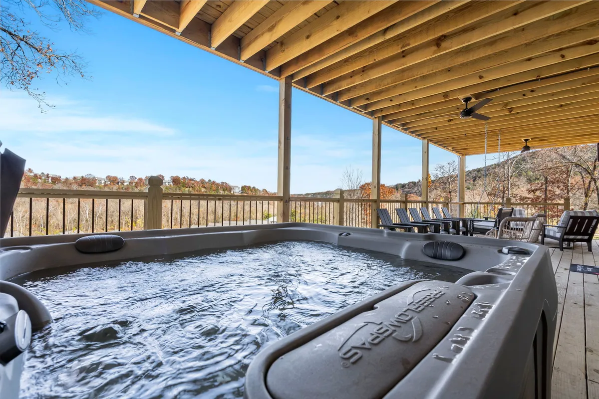 This image captures a tranquil hot tub set on a deck with expansive views of surrounding nature. The setting is ideal for relaxing after a day of lakeside fun, socializing with family, or sipping morning coffee with the outdoors as a backdrop.