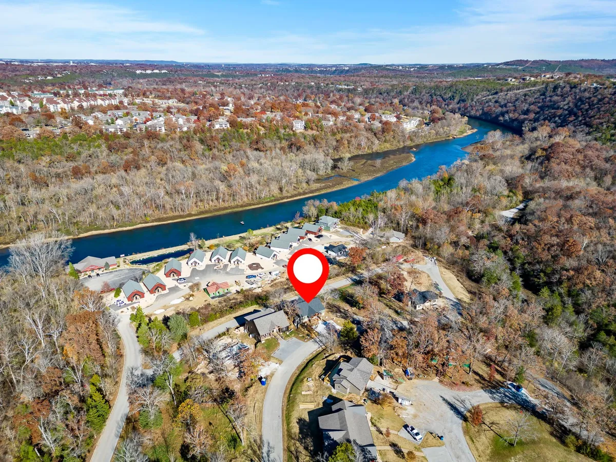 A tranquil view over a river with surrounding hills and autumn foliage, capturing the natural beauty and recreational opportunities nearby. This serene landscape invites exploration and underscores the availability of hiking, biking, and lakeside activities.